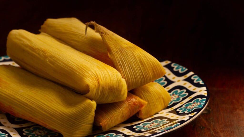 Tamales de pollo con masa amarilla envueltos en hojas de maíz